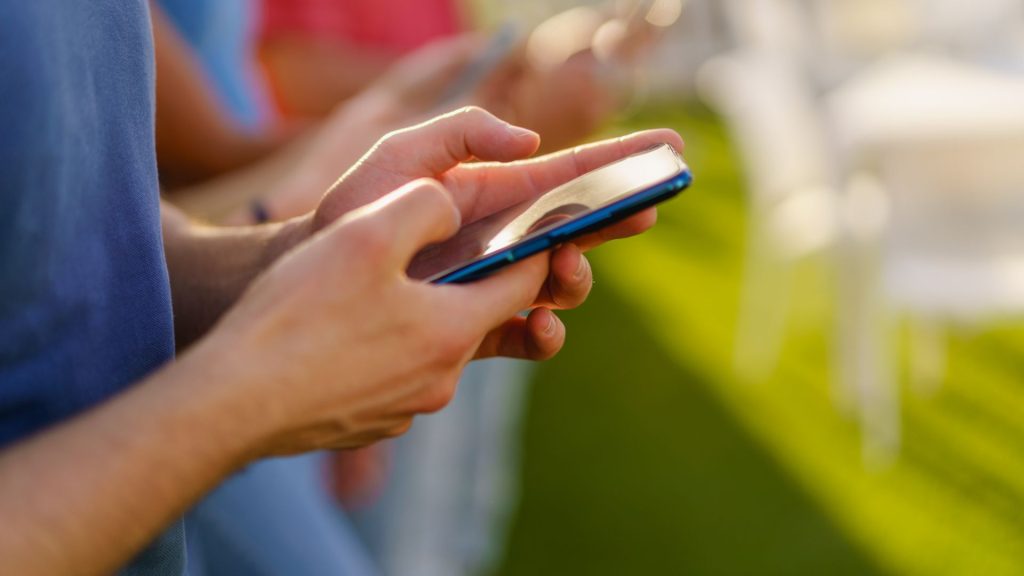 closeup of hands using smartphones outdoors 2022 04 12 14 22 29 utc 1